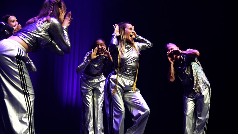 Trois danseuses en tenues argentées, en gros plan.