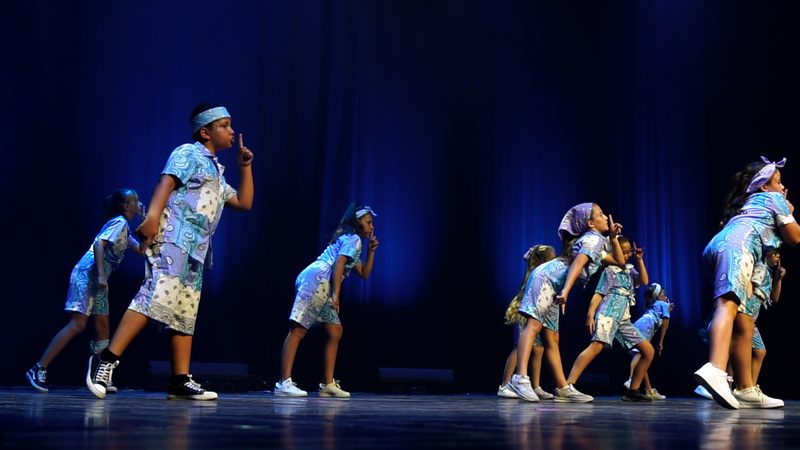 Les enfants en tenues bleues imprimées et casquettes, une main devant la bouche.