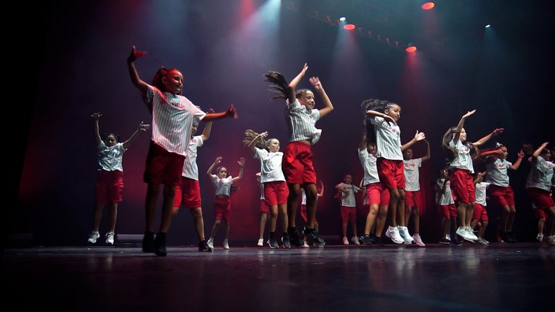 Les enfants en tee-shirts blancs et shorts rouges, sous une lumière rouge.