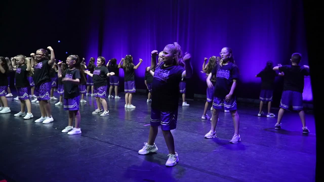 Le groupe hip-hop des 9-11 ans en tenues violettes, en formation serrée sur scène.