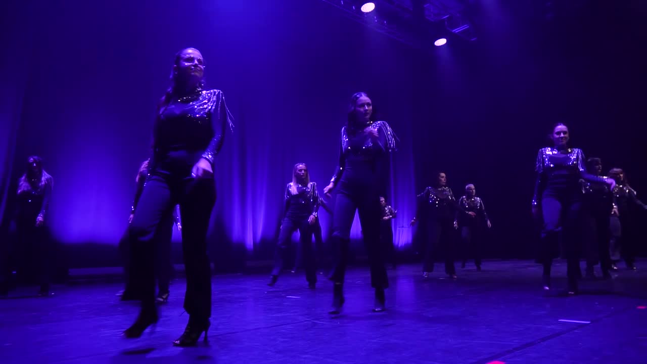 Le groupe talons en noir, sur une scène qui passe du bleu au rouge.